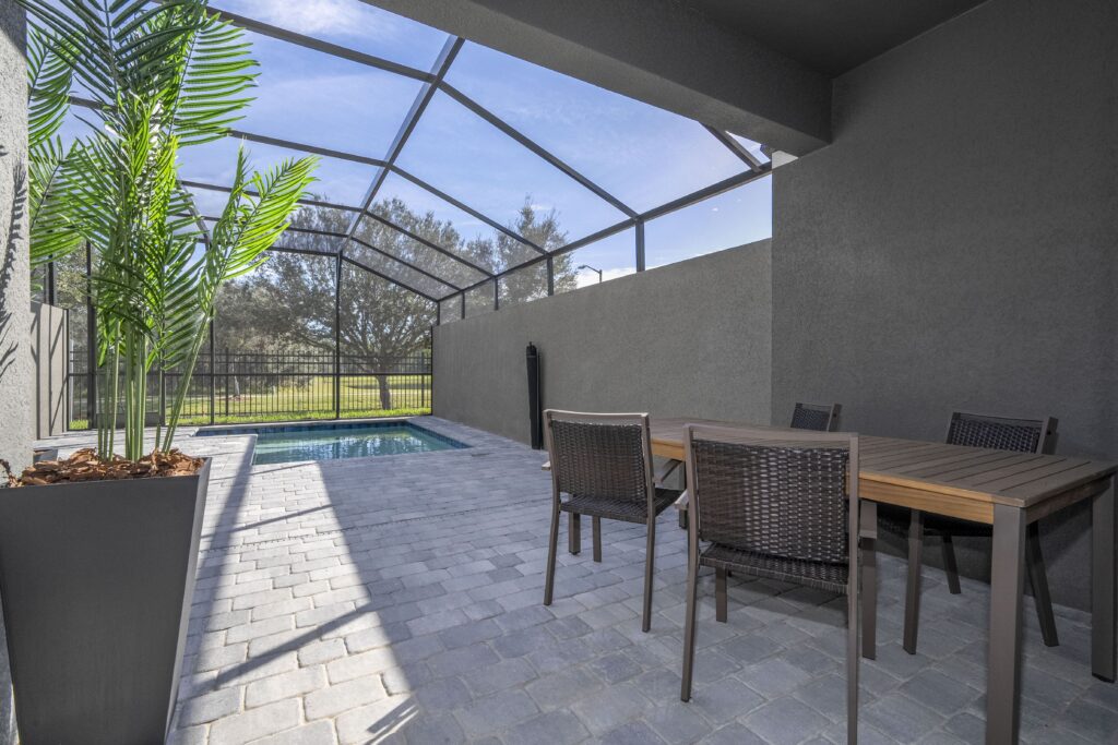 Piscina privada de Doppio Westside con área exterior, mesa y palmera en Kissimmee